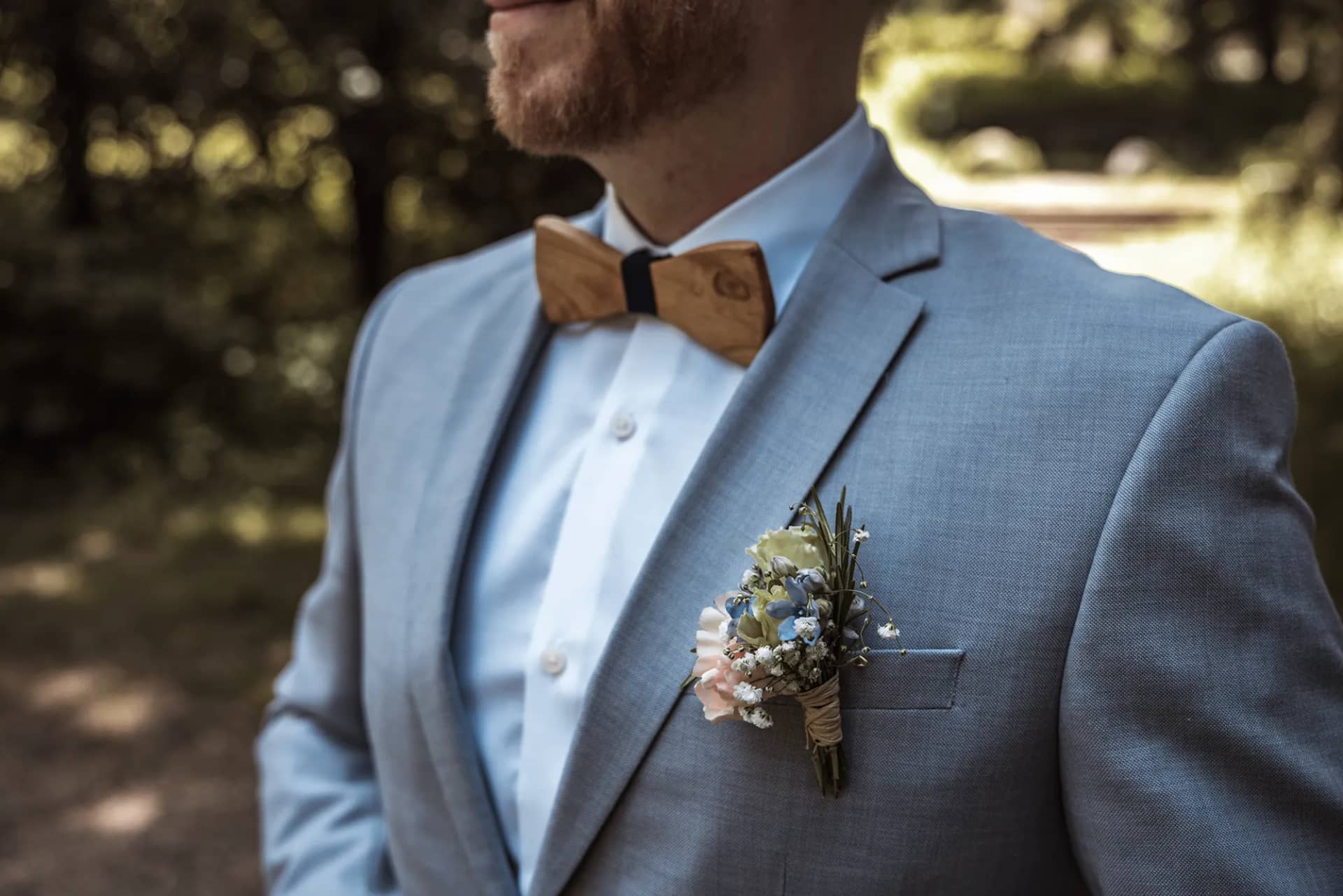 Nahaufnahme des Bräutigams in einem blauen Anzug mit Boutonniere in Freiburg.