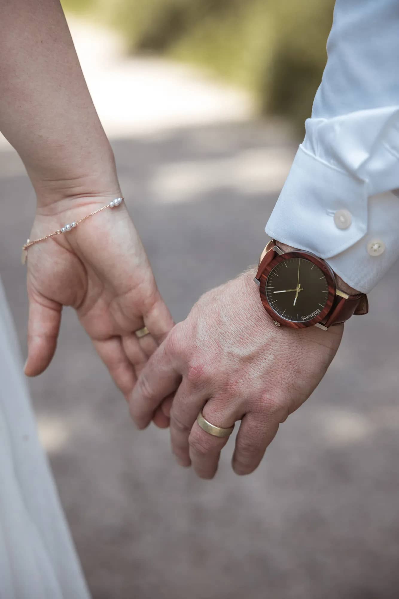 Nahaufnahme der Hände des Brautpaares, die ihre Eheringe zeigen, während der Hochzeit in Freiburg.