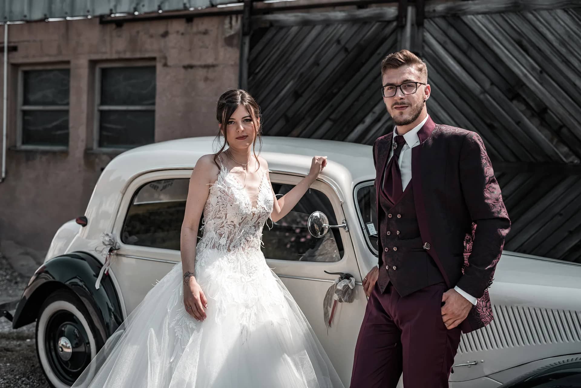 Braut und Bräutigam teilen einen romantischen Moment vor einem Auto bei ihrer Hochzeit in Strasbourg, Frankreich.