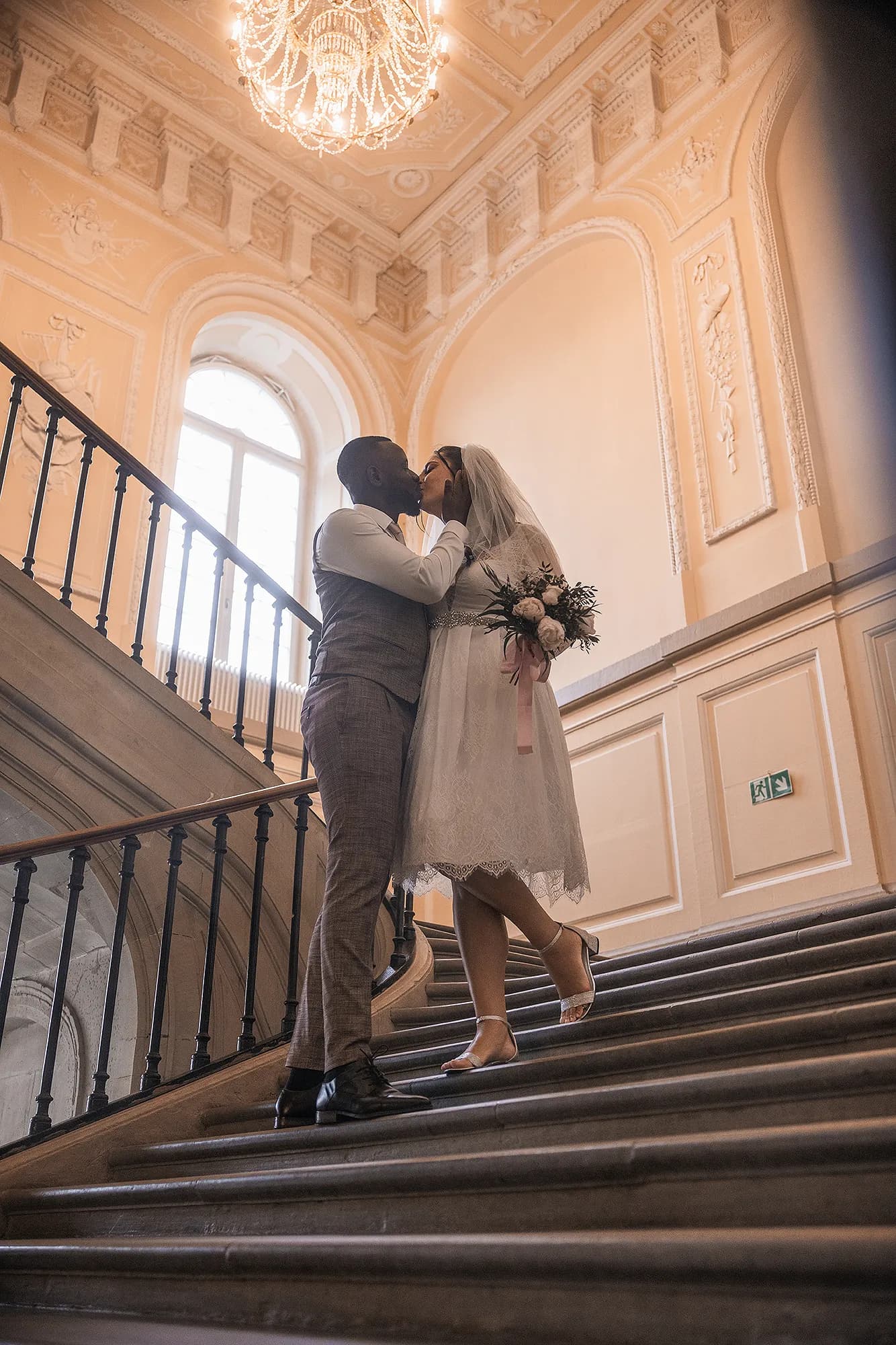 Brautpaar auf einer Treppe im Schloss Hohenheim
